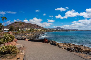 Playa Blanca 'daki tatil bölgesinin manzarası ve arka planda volkanik manzaralı gezinti alanı