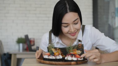 Kafe konsepti 4k Kararlılık. Mağazalarda pasta süsleyen Asyalı kızlar.