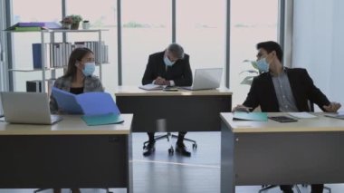 4k Kararlılığın iş konsepti. Çalışanlar maske takarak çalışırken kendilerini koruyorlar..