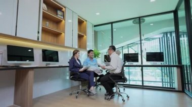 4k Kararlılığın iş konsepti. Asyalı genç iş adamları grubu ofiste toplantı yapıyor. Sıradan iş planı.