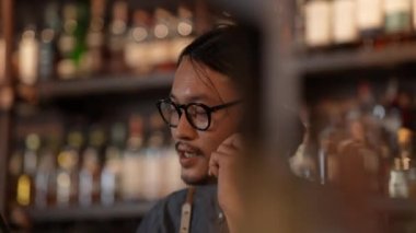 Night club concept of 4k Resolution. The bartender is taking orders from customers with the phone in the restaurant. A group of specialized clubs that sell alcoholic beverages.