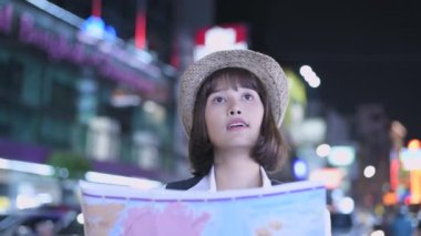 Seyahat konsepti 4k Çözünürlük. Asyalı kadınlar şehirde yer bulmak için haritalar kullanıyorlar..