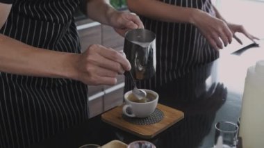 Kafe konsepti 4k Kararlılık. Kahveci kahve makinesiyle latte sanatı yapıyor..