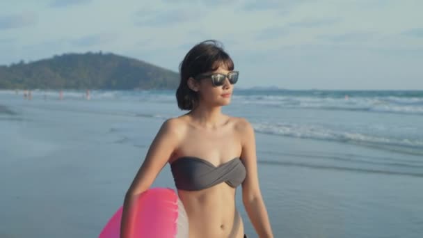 假日4K解像度的概念 这个女孩在海滩上玩橡皮圈很开心 — 图库视频影像