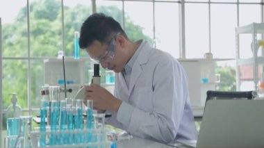 Araştırma konsepti 4K çözünürlüğü. Asyalı bilim adamları anomaliyi mikroskopla inceliyorlar..