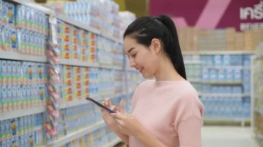 4k Kararlılığın alışveriş kavramları. Genç kadınlar alışveriş merkezinde mal aramak için cep telefonu kullanırlar..