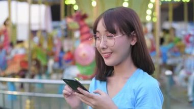 Tourism concept of 4k Resolution. Asian woman taking pictures of scenery in amusement park.