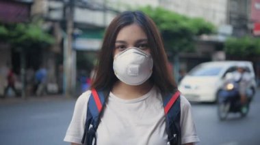 Sağlıklı bir 4k çözünürlük kavramı. Asyalı kadın şehir sokaklarında toz ve kirliliğe karşı kampanya yürütüyor.