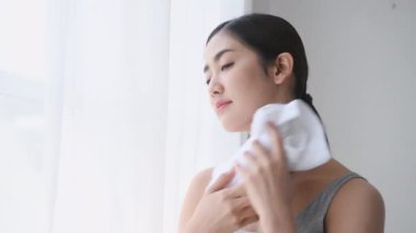 Tatil konsepti 4k Çözünürlük. Asyalı bir kadın evde havluyla yüzünü terletiyor..