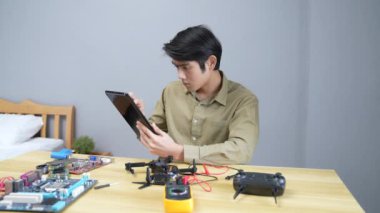 Teknoloji konsepti 4k Çözünürlük. Asyalı adam odada drone tamir ediyor. hasar kontrolü.