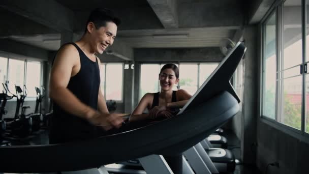 4K解像度的健康概念 亚洲男人和女人在健身房锻炼时交谈 — 图库视频影像