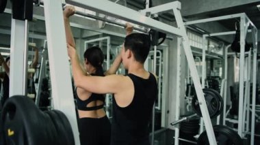 Fitness konsepti 4k Çözünürlük. Bir antrenör sporculara spor salonunda çömelme hareketleri öğretiyor..
