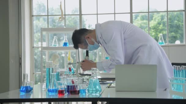 Forskningskoncept För Upplösning Asiatiska Forskare Undersöker Anomalin Med Ett Mikroskop — Stockvideo