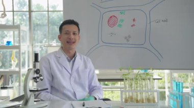 Araştırma konsepti 4K çözünürlüğü. Asyalı erkek bilim adamı laboratuvar iş akışıyla röportaj yapıyor.