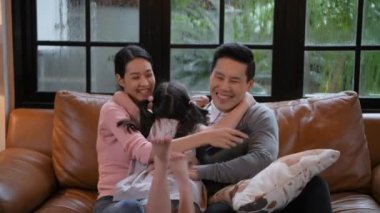 Aile kavramı 4k Kararlılığı. Asyalı ebeveynler ve çocuklar tatilde evde birlikte film izliyorlar..