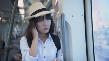 4k Kararlılığın Turizm konsepti. Asyalı bir kız metroda seyahat ederken müzik dinliyor..