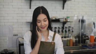 Kafe konsepti 4k Kararlılık. Bir çalışan, içki siparişi vermek için arayan bir müşterinin telefonuna cevap veriyor..