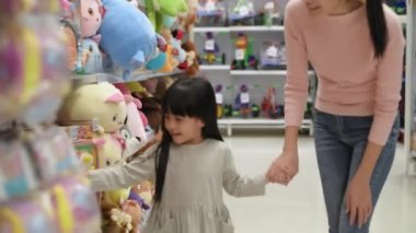 Shopping concepts of 4k Resolution. Asian mother and daughter are buying dolls in the mall.