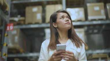 Shopping concept of 4k Resolution. Asian female customer checking price by mobile phone in warehouse.