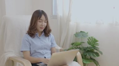 Tatil konsepti 4k Çözünürlük. Asyalı kız oturma odasında bilgisayarla çalışıyor..