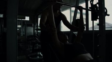 Fitness konsepti 4k Çözünürlük. Spor salonunda ağırlık kaldırmayı öğreten antrenör..
