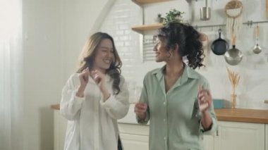 Tatil konsepti 4k Çözünürlük. Asyalı kadınlar mutfakta birlikte dans ediyorlar. Genç kadınların ortak bir lezbiyen ilişkisi var..