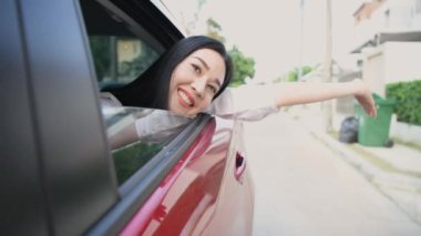 Tatil konsepti 4k Çözünürlük. Asyalı kadın neşeyle arabanın camından el sallıyor..