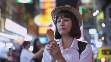 4k Kararlılığın Turizm konsepti. Asyalı kadın şehirde dondurma yemekten zevk alıyor..