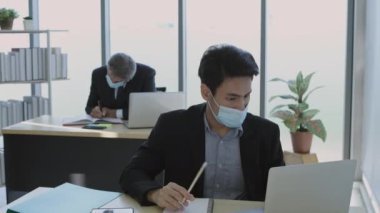 4k Kararlılığın iş konsepti. Çalışanlar maske takarak çalışırken kendilerini koruyorlar..