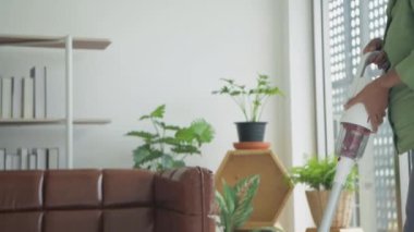 Tatil konsepti 4k Çözünürlük. Asyalı yaşlı bir kadın oturma odasını süpürüyor..