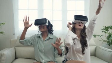 Tatil konsepti 4k Çözünürlük. Asyalı kadınlar oturma odasında videoyu birlikte kullanırlar. sanal gerçeklik teknolojisi.