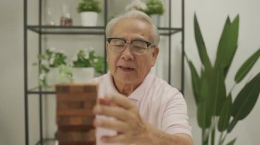 Tatil konsepti 4k Çözünürlük. Asyalı kız ve baba evde tahta bloklarla oynuyorlar. Faaliyetler ve aile içi ilişkiler.