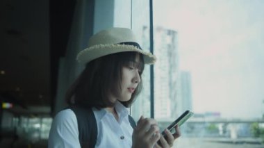 4k Kararlılığın Turizm konsepti. Binada cep telefonuyla oynayan Asyalı kadın..