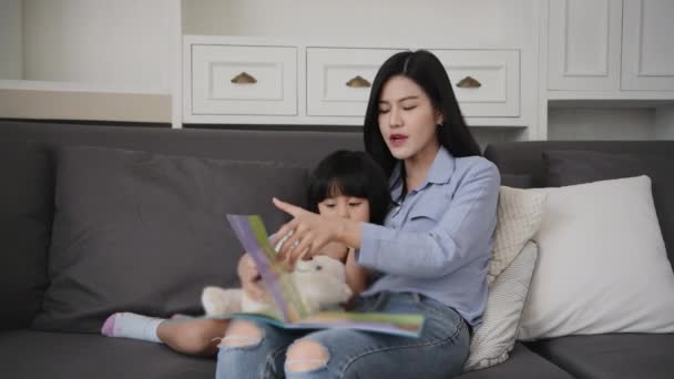 Aile Kavramı Kararlılığı Anne Kızı Oturma Odasında Birlikte Kitap Okuyorlar — Stok video