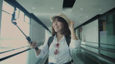 4k Kararlılığın Turizm konsepti. Asyalı kadın havaalanında selfie ya da video çekiyor..