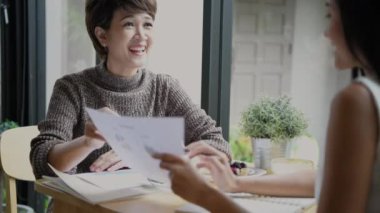 4k Kararlılığın iş konsepti. Asyalı iş adamları bir kahve dükkanında toplantı yapıyorlar. Sıradan iş planı.