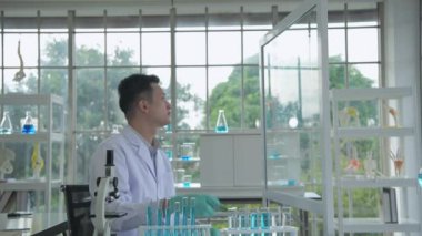 Araştırma konsepti 4K çözünürlüğü. Asyalı bilim adamları anomaliyi mikroskopla inceliyorlar..