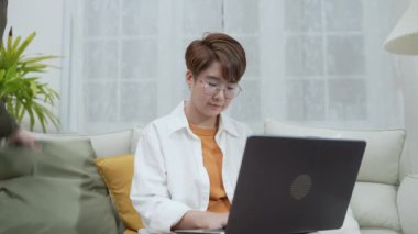 Tatil konsepti 4k Çözünürlük. Asyalı kadınlar oturma odasında dizüstü bilgisayar oynuyorlar. Genç kadınların ortak bir lezbiyen ilişkisi var..
