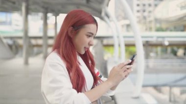 Tatil konsepti 4k Çözünürlük. Şehirde cep telefonu çalan Asyalı kadın..