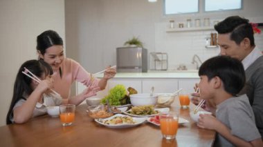 Family concept of 4k Resolution. Asian parents and children eating together in the house.