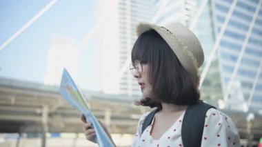 Seyahat konsepti 4k Çözünürlük. Asyalı kadınlar şehirde yer bulmak için haritalar kullanıyorlar..