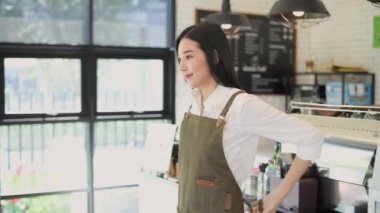 Coffee shop concept of 4k Resolution. Asian women are preparing to open a shop with confidence. Employee wearing aprons.
