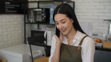 Kafe konsepti 4k Kararlılık. Bir çalışan, içki siparişi vermek için arayan bir müşterinin telefonuna cevap veriyor..