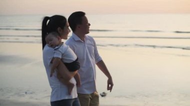 4k Kararlılığın Turizm kavramları. Sahilde birlikte yürüyen Asyalı bir aile..