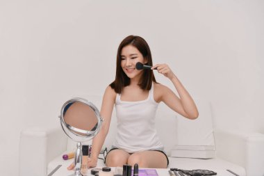 Evde makyaj yapan güzel bir kız. Yüzüne bakan Asyalı kadın..