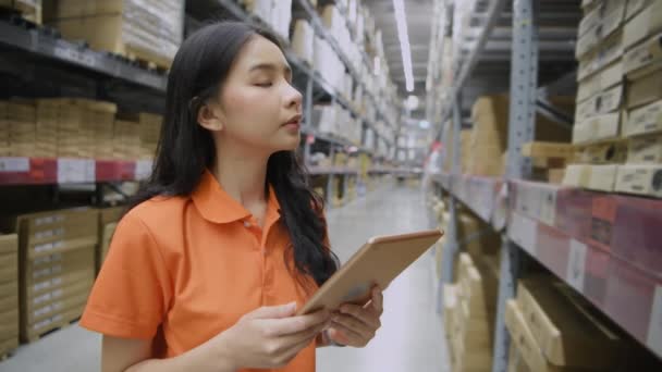 4K解析度的业务概念 一位亚洲妇女正在用现代技术检查仓库里的产品 — 图库视频影像
