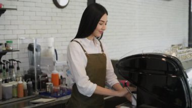 Kafe konsepti 4k Kararlılık. Asyalı bir kadın dükkanda güvenle kollarını kavuşturuyor..