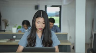 4k Kararlılığın iş konsepti. Ofiste dizüstü bilgisayar kullanan Asyalı iş kadını..