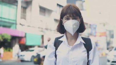 Sağlıklı bir 4k çözünürlük kavramı. Asyalı kadın şehir sokaklarında toz ve kirliliğe karşı kampanya yürütüyor.