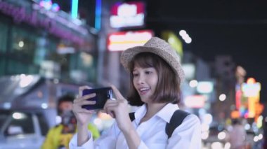 Travel concept of 4k Resolution. Asian woman taking pictures on the street while traveling.
